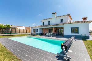 a villa with a swimming pool in front of a house at Casa Amizade in Aljezur