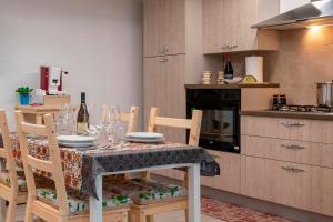 una cucina con tavolo, piatti e bicchieri da vino di Casa Vacanza Francesca a Menfi