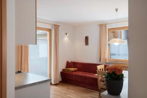 een woonkamer met een rode bank en een raam bij Hilber App Furchetta in Villnoss