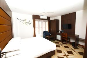 ein Hotelzimmer mit einem Bett und einem Schreibtisch in der Unterkunft Ashoka Resort Pvt. Ltd in Chitwan