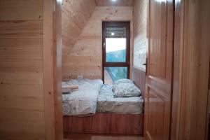 Kleines Zimmer mit einem Bett und einem Fenster in der Unterkunft Villa Route Rugove in Peja