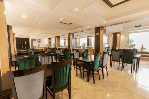 a dining room with green chairs and tables at Prince de Paris in Casablanca