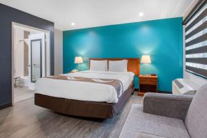a bedroom with a large bed and a blue wall at Quality Inn Near Hollywood Walk of Fame in Los Angeles