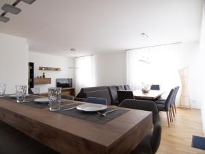 a dining room with a wooden table and chairs at Rooftop Tulln operated by revLIVING in Tulln