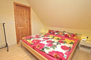 マルヒョーにあるFerienhaus Malchow SEE 4901のベッドルーム1室(花柄の掛け布団付きの大型ベッド1台付)