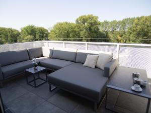 a couch sitting on top of a balcony at Rooftop Tulln operated by revLIVING in Tulln