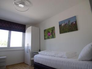 a bedroom with two beds and a desk and a window at Rooftop Tulln operated by revLIVING in Tulln