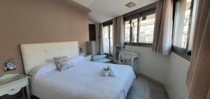 Un dormitorio con una cama blanca con flores. en Apartamentos Torre de la Mezquita, en Córdoba