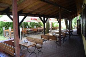 een paviljoen met houten tafels en banken in een restaurant bij Chata Mazurska Marek Pyśk in Mrągowo