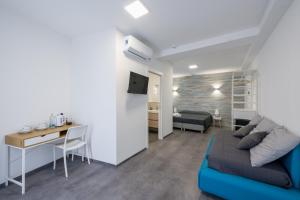 - un salon avec un canapé bleu et un bureau dans l'établissement Hotel Nuovo Cason, à Cavallino-Treporti