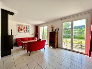 Una sala de estar con un sofá rojo y una mesa. en COC - Les Muriades, en Wissant