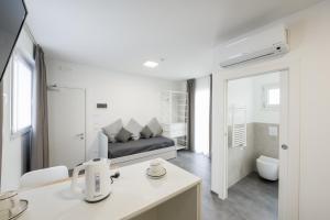a white room with a bed and a bathroom at Boutique Hotel Nuovo Cason in Cavallino-Treporti