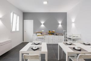 a kitchen with white tables and chairs and a counter at Boutique Hotel Nuovo Cason in Cavallino-Treporti