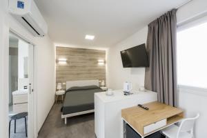 a room with a bed and a desk with a television at Boutique Hotel Nuovo Cason in Cavallino-Treporti