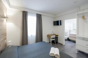 a bedroom with a bed and a desk and a television at Boutique Hotel Nuovo Cason in Cavallino-Treporti