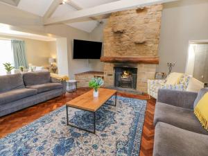 a living room with a couch and a fireplace at Burns Cottage in Barnard Castle