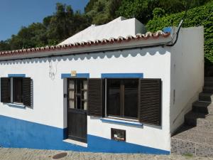 a white house with blue trim and a door at Casa do Gerd in Aljezur