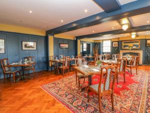 a restaurant with wooden tables and chairs and a rug at Burns Cottage in Barnard Castle