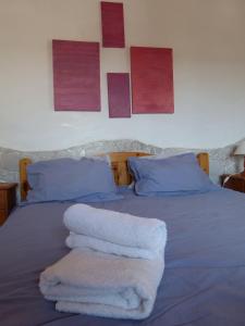 Una cama con tres toallas encima. en Casa do Gerd, en Aljezur