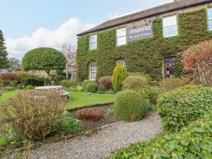 a garden in front of a green building at Burns Cottage in Barnard Castle