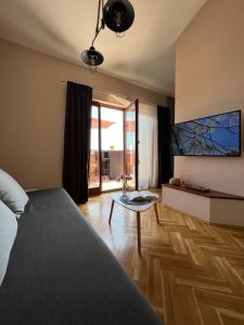 a bedroom with a bed and a table and a window at Apartman Maroon - Savršen pogled i miran odmor in Lovran