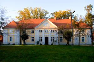 uma grande casa branca com um telhado vermelho em Pałac Wąsowo em Wąsowo