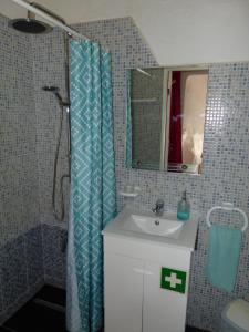 a bathroom with a shower curtain and a sink at Casa do Gerd in Aljezur