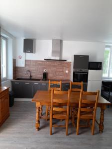 - une cuisine avec une table et des chaises en bois dans l'établissement 5km de beauval, gîte l'étoile des châteaux, à Noyers-sur-Cher