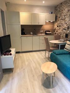 uma sala de estar com um sofá azul e uma cozinha em Vieil Antibes, ravissant 2p avec petite terrasse em Antibes