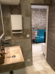 uma casa de banho com um lavatório e um sofá num quarto em Vieil Antibes, ravissant 2p avec petite terrasse em Antibes