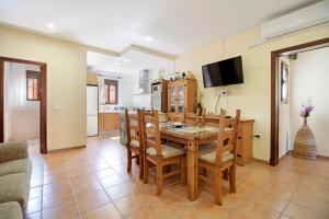 cocina y comedor con mesa y sillas en Casa rural El Campo, en Chiclana de la Frontera