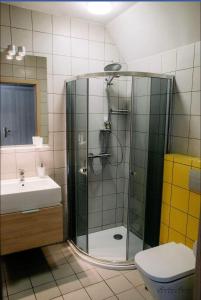 y baño con ducha, aseo y lavamanos. en Na Fali Restaurant&Apartaments, en Pobierowo
