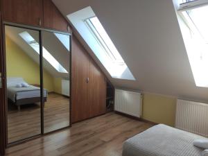 ein Schlafzimmer im Dachgeschoss mit Oberlichtern und einem Bett darin in der Unterkunft Apartament Pod Lasem in Police