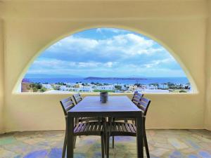a table and chairs in a room with a large window at Mosaic Suites in Drios