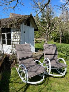 two chairs sitting in the grass next to a house at LAND-Häusle in Weikersheim