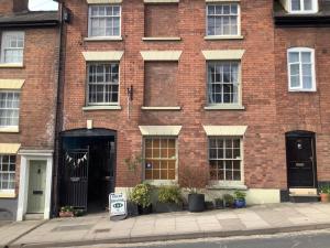a brick building with a for sale sign in front of it at Green Dragon LUDLOW in Ludlow