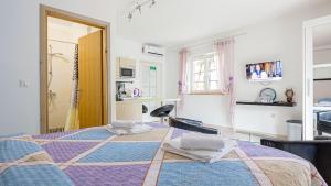 a bedroom with a bed with a purple blanket at Apartments Klara in Senj