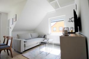 een witte woonkamer met een bank en een tafel bij Haus Barbara - Schwimmbad und Sauna im Haus-Whg 11 in Grömitz