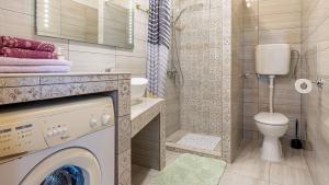 a bathroom with a washing machine and a toilet at Apartments Klara in Senj +34 photos
