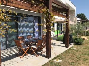 une terrasse avec une table et des chaises dans une maison dans l'établissement Villa Rosa dei Venti - Peroj - Amazing sea view, à Peroj
