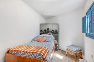 a small bedroom with a bed and a chair at Casa Bene in Güimar