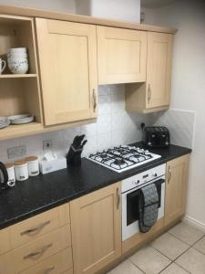 cocina con armarios de madera y fogones en Beautiful 2 bed apartment, en Grantham