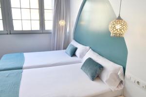 1 dormitorio con 2 camas y 2 ventanas en Hotel Alda Puerta Del Sol, en Vigo