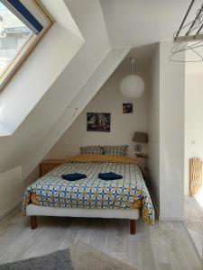 een slaapkamer met een bed op zolder bij Chaleureuse petite maison de bourg in Beaumont-sur-Sarthe
