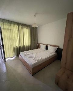 een slaapkamer met een groot bed met witte lakens bij Studio 8 Arapya in Tsarevo