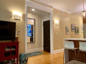 a living room with a kitchen with a counter and a television at 1F Cozy Home in Little Italy near Downtown West Loop United Center in Chicago