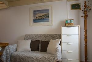 a living room with a couch and a dresser at Stonehouse with wonderful seaview in Samos