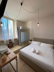 a bedroom with a large white bed and a table at Locanda Garzelli in Quercianella