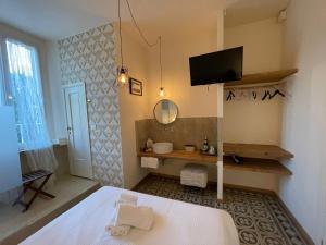 um quarto com uma cama e uma televisão na parede em Locanda Garzelli em Quercianella