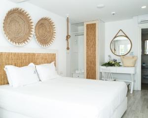 a white bedroom with a large white bed and a desk at Blue Harbour Boutique in Ayia Napa